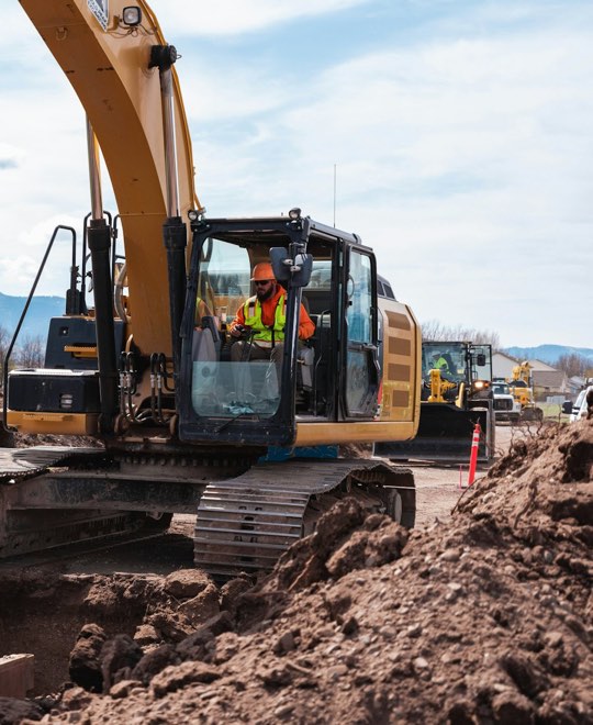 Excavator grading dirt on a construction site